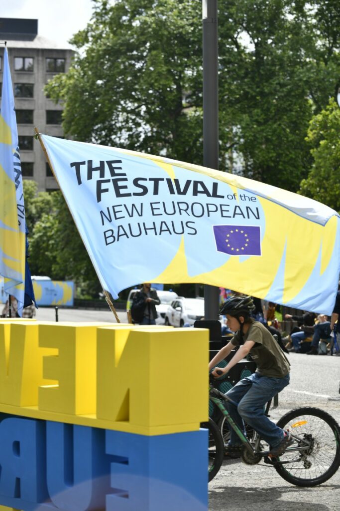 A boy riding a bike around the festival grounds during the New European Bauhaus 2026